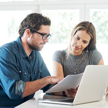A couple reviews their college savings accounts in front of a computer.